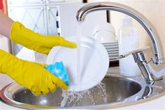 a person in yellow gloves is washing dishes