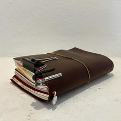 a brown leather binder with several books stacked on it