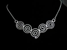 I like spirals and in Celtic lore, they can represent going from stages of oneself primal points to enlightenment, and though most of us have a way to go, we can at least adorn one in hopes of always continuing on a path of growth and self-reflection. This Celtic Spiral Necklace, in sterling silver, with each scroll hand-made in alternating plain and twist 16 gauge wire, embodies Celtic symbolism. I wanted to fabricate something meaningful and magical within the spirit of these ancient symbols. Silver Spiral Bohemian Necklace, Bohemian Silver Spiral Necklace, Artistic Spiral Wire Wrapped Jewelry, Artistic Wire Wrapped Spiral Jewelry, Artistic Handmade Spiral Jewelry, Artistic Handmade Swirl Jewelry, Artistic Spiral Nickel-free Jewelry, Celtic Symbolism, Spiral Symbol