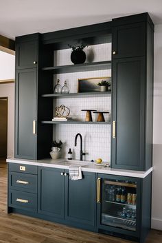 a kitchen with dark green cabinets and white counter tops, gold trim on the doors