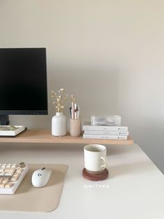 a desk with a computer monitor, keyboard and mouse on it next to other office supplies