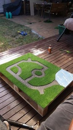 a child's play area made out of grass with a toy car on it