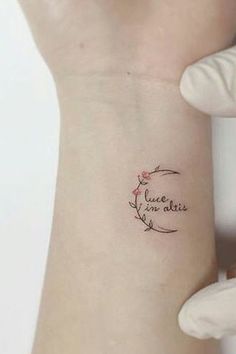 a woman's arm with a small tattoo on it that says love is in the air