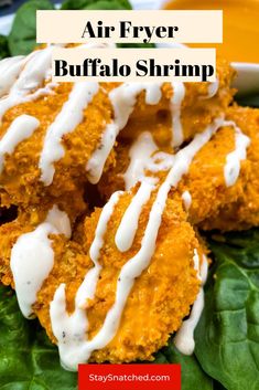 an air fryer buffalo shrimp is on top of spinach leaves and drizzled with white sauce