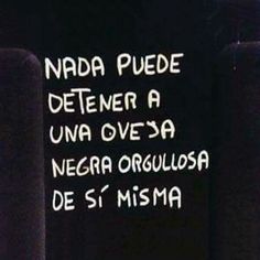 a black and white photo with words written in spanish on the side of a wall