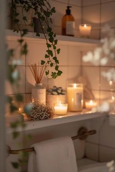 candles and flowers are on the shelf in this bathroom