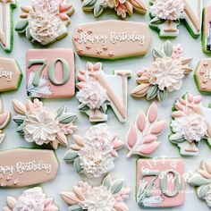 decorated birthday cookies with flowers and leaves on a white tablecloth for a 70th birthday