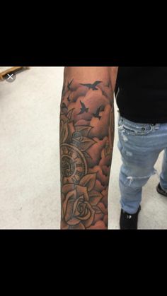 a person with a clock and roses tattoo on their arm is looking at the camera