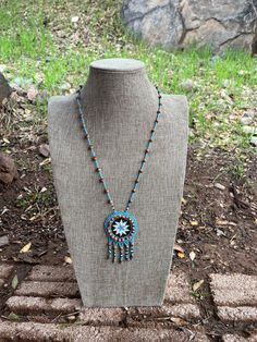 Artist: Marlene Huskie Tribe: Navajo Materials used: Juniper Berry Seeds, Hematite, and Glass Beads Hangs 20" from top of necklace to bottom of fringes Top of Necklace to Medallion Top is 13 1/4" Medallion is 3" Top of Medallion to bottom of fringes is 6 3/4" The Juniper Berry Seeds Dine (Navajo) mother placed bracelets or necklaces or Tsidze' (Juniper Berry Seeds) on their children to protect them from evil spirits and bad dreams.  Adults would also place the berries in their mouths for protect Southwestern Fringe Jewelry With Round Beads, Life Journey, Juniper Berry, Fringe Top, Bad Dreams, Medallion Necklace, Evil Spirits, Inner Strength, Seed Beads