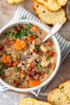 a white bowl filled with soup next to slices of bread