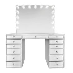 a white dressing table with drawers and lights on the top, in front of a mirror