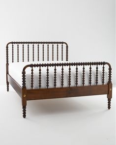 a wooden bed frame with beads on the headboard and foot board, against a white background