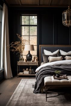 a bedroom with black walls and wooden flooring has a large bed in front of the window