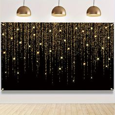 three lamps hanging from the ceiling in front of a black wall with gold stars on it