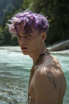 a young man with purple hair standing in front of a body of water wearing chains