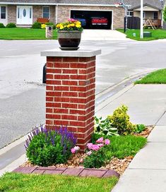 a brick mailbox with flowers growing out of it