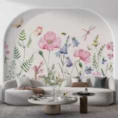 a living room with flowers painted on the wall and a white couch in front of it