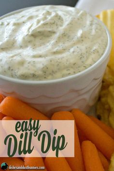 a white bowl filled with dip surrounded by carrots