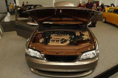 a car with its hood open in a showroom