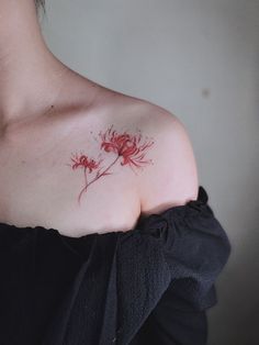 a woman's shoulder with red ink on it and flowers in the middle of her chest