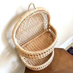 two wicker baskets sitting on top of a wooden table next to a white wall