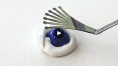 a fork sticking out of an egg shell with blue and white paint on it's side