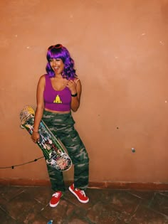 a woman with purple hair holding a skateboard in front of a wall and posing for the camera