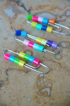 three colorful clips are sitting on a marble surface