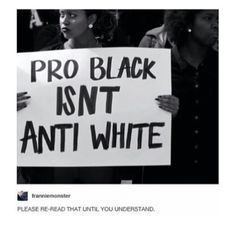 people holding signs that read pro black isn't anti white