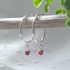 A beautiful pair of sterling silver hoop earrings with a small simulated Garnet drop, the birthstone forJanuary. These earrings make a lovely gift for someone born in January for a birthday or Christmas gift or for Mother's Day. They also make a great gift for a bridesmaid born in January or a new Mum with aJanuary born baby. The Sterling Silver Hoops measure 15mm in diameter and the Garnet drops are a dainty 3mm in diameter. These Sterling Silver and Garnet Janaury Birthstone Hoop Earrings will Silver Huggie Earrings With Birthstone, Anniversary Birthstone Hoop Earrings, Teardrop Hoop Earrings As May Birthstone Gift, Sterling Silver Birthstone Hoop Earrings, Dainty Sterling Silver Hoop Earrings With Gemstone, Dainty Gemstone Hoop Earrings As Gift, Everyday Sterling Silver Hoop Earrings With Birthstone, Silver Small Hoop Jewelry For Birthday, Silver Small Hoop Earrings For Birthday