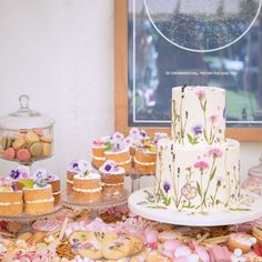 a table topped with lots of cakes and desserts