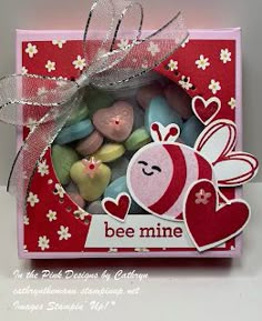 a card with some candy in the shape of a bee and heart on it's side