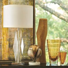 an assortment of glass vases and lamps on a table