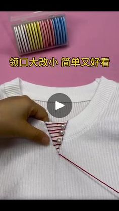 someone is stitching a t - shirt with scissors