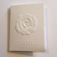 a chanel box with a white rose on it's side and the word chanel written in large letters