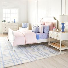 a bedroom with a bed, dresser and nightstands in the corner is white and has blue accents