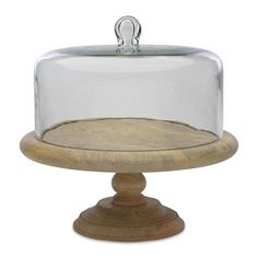 a wooden base with a glass covered cake on it's top and bottom layer