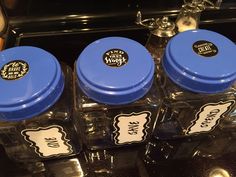 three glass jars with stickers on them