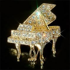 a gold colored piano sitting on top of a black table next to a green light