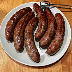 a white plate topped with lots of cooked sausages