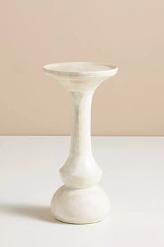 a white vase sitting on top of a table