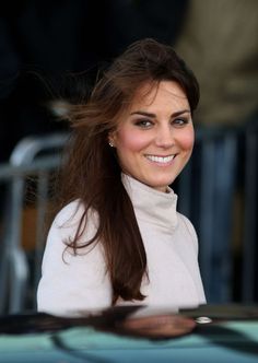 a woman with long hair is smiling at the camera