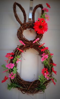 a close up of a wreath on a door with flowers in the shape of an animal's head