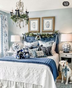 a bedroom decorated for christmas with blue and white decorations on the bed, chandelier and pillows