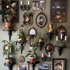 there are many pictures on the wall with candles and flowers in vases next to them