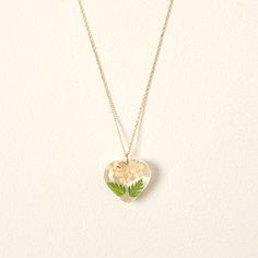 a heart shaped necklace with flowers on it