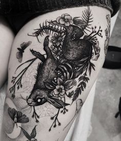 a woman's thigh with a deer and flowers on it