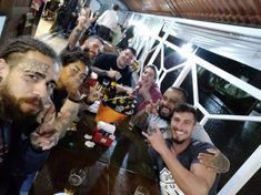 a group of people sitting around a wooden table