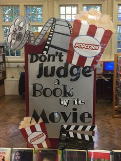 a sign that says don't judge a book by its movie in front of some movies