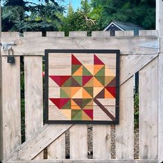 a wooden fence with a quilt hanging on it